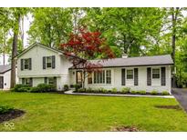 Charming brick and clapboard home with lush landscaping and a well-manicured lawn at 7531 Mohawk Ln, Indianapolis, IN 46260