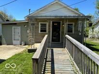 Charming single-story home with a textured exterior, accessible ramp, and a cozy, covered front porch at 909 Hickory St, Anderson, IN 46012