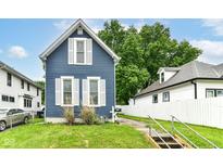 Charming blue two-story home featuring white trim, symmetrical windows, and a well-maintained lawn at 1115 N Keystone Ave, Indianapolis, IN 46201