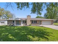 Charming brick ranch home featuring a lush green lawn and attached two-car garage at 1328 Toner Dr, Anderson, IN 46012