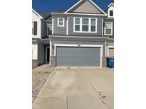 Attached two-car garage with gray door and driveway at 13460 Dewpoint Ln, Fishers, IN 46037