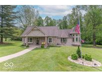 Charming home featuring a well-manicured lawn, American flag, and cozy front porch at 1409 S Northview Dr, Martinsville, IN 46151