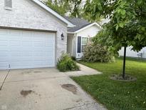 Charming single-story home with a white brick facade, attached garage, and well-maintained lawn at 1716 W Witt Ave, Lebanon, IN 46052
