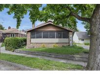 Charming single-story home with a brick facade, a well-kept lawn, and mature shade trees at 309 Poplar Rd, Indianapolis, IN 46219