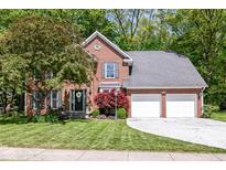 Charming brick two-story home with attached two-car garage and a well-manicured front lawn at 310 Wellington Overlook, Noblesville, IN 46060