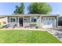 Charming single-story home with a well-manicured lawn, flowering garden and inviting front porch at 3608 Valley Lake Dr, Indianapolis, IN 46227