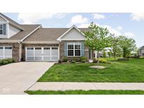 Charming brick home featuring a two-car garage, blue shutters, and a well-maintained lawn with landscaping at 4034 Cairo Way, Avon, IN 46123