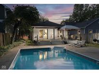 Inviting backyard pool and deck area with lounge chairs and a covered dining space, perfect for outdoor entertaining at 6167 Carrollton Ave, Indianapolis, IN 46220