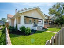Charming craftsman-style home featuring a covered porch, manicured lawn, and attractive landscaping at 625 Dequincy St, Indianapolis, IN 46201