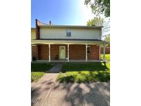 Charming brick and vinyl two-story home with covered front porch and well-maintained lawn at 6432 Commons Dr, Indianapolis, IN 46254