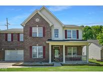 Charming two-story home with brick facade, red shutters, covered porch, and well-maintained lawn at 6913 Thousand Oaks Ln, Indianapolis, IN 46214