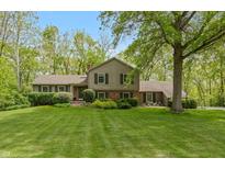 Charming two-story home featuring a lush green lawn and mature trees, providing a serene setting at 7189 Creekwood Estates, Brownsburg, IN 46112