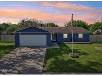 Charming single-story home with a well-manicured lawn and attached garage at 7645 Madden Dr, Fishers, IN 46038