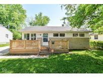 Charming home featuring a cozy front deck, stone accents, and a well-maintained lawn at 7849 E 49Th St, Indianapolis, IN 46226