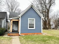 Charming single-Gathering home featuring light blue siding, crisp white trim, and a well-maintained lawn at 929 W Roache St, Indianapolis, IN 46208