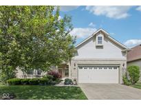 Charming home featuring a two-car garage, landscaped yard, and beautiful brick accents at 9760 Innisbrook Blvd, Carmel, IN 46032