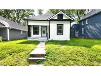 Charming bungalow with black and white trim, featuring a small front porch and walkway to the home at 1148 N Pershing Ave, Indianapolis, IN 46222