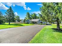 Landscaped front yard with a long driveway leading to a charming single-story home at 12681 E 79Th St, Indianapolis, IN 46236