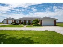 Ranch style home with brick facade, attached garage, large yard, and additional detached garage at 133 W Us Highway 52, Fountaintown, IN 46130