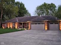 Charming brick home with a well-manicured lawn, updated garage doors, and warm exterior lighting at 1515 Renee Dr, Plainfield, IN 46168