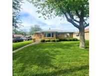 Charming brick home with a well-manicured lawn and mature landscaping at 2150 Main St, Beech Grove, IN 46107