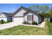 Charming single-story home featuring a well-manicured lawn, attached garage, and delightful curb appeal at 320 Red Tail Ln, Indianapolis, IN 46241