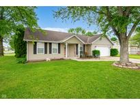 Lovely home featuring mature trees, manicured lawn, an attached garage and welcoming front porch at 3334 Old Field Ln, Columbus, IN 47203