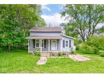 Charming gray two-story home with front porch and well-maintained lawn at 42 E Brookville Rd, Fountaintown, IN 46130