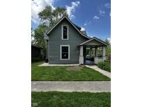 Charming two-story home with a covered front porch, green lawn, and mature trees at 44 S Butler Ave, Indianapolis, IN 46219