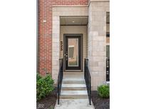 Contemporary townhome featuring a glass front door, brick and stone accents, and a welcoming entrance at 525 Fynn Pl, Indianapolis, IN 46202