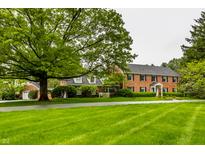 Brick home with lush green lawn and mature trees creates a charming curb appeal at 5356 S U.S. Highway 421, Zionsville, IN 46077