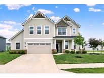 Charming two-story home features a well-manicured lawn, attached garage, and inviting front porch with white pillars at 5366 Laurel Crest Run, Noblesville, IN 46062