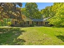 Charming brick home featuring a well-manicured lawn, mature trees, and classic architectural details at 5920 Crooked Creek E Dr, Martinsville, IN 46151