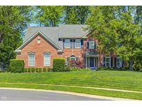 Charming two-story brick home with a landscaped front yard, mature trees, and classic architectural details at 6374 Timberbluff Cir, Avon, IN 46123