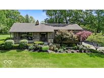 Charming home featuring lush landscaping and inviting front porch with stone accents at 665 Spring Hills Dr, Zionsville, IN 46077