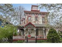 Charming Victorian-style home featuring a classic front porch, red trim and distinctive architectural details at 866 Fletcher Ave, Indianapolis, IN 46203
