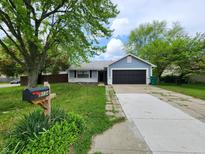 Charming home featuring a two-car garage, lovely landscaping, and a well-maintained front yard at 9134 Jene Ct, Indianapolis, IN 46234