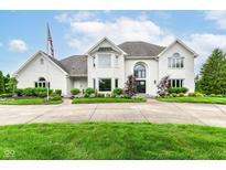 Stunning white brick home features a beautifully landscaped yard and a circular driveway at 9790 Summerlakes Dr, Carmel, IN 46032