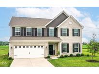 Charming two-story home featuring a brick facade, black shutters, attached garage, and well-manicured front lawn at 9860 Gallop Ln, Fishers, IN 46040