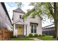 Charming two-story home with a bright yellow front door and manicured lawn at 1043 N Beville Ave, Indianapolis, IN 46201