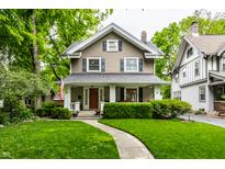 Charming two-story home featuring a well-manicured lawn and inviting front porch at 114 E 44Th St, Indianapolis, IN 46205