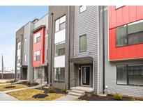 Modern townhome featuring a vibrant red accent and stylish gray and brick facade at 1322 Colere Pl, Indianapolis, IN 46203