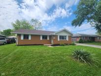 Charming single-story home with a well-manicured lawn and simple landscaping at 1614 Dayton Ave, Indianapolis, IN 46203