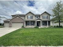 Charming two-story home featuring a welcoming front porch and three-car garage at 2680 Newington Ln, Carmel, IN 46074
