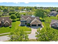 Beautiful home boasts professional landscaping, a two-car garage, and a peaceful pond view at 28 Hudson Bay Ln, Greenwood, IN 46142