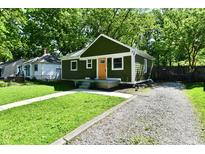 Charming one-story home with a green exterior, orange door, and well-maintained lawn at 3021 Eastern Ave, Indianapolis, IN 46218