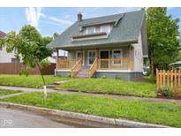 Charming home featuring a covered front porch, green roof, and manicured lawn at 3216 N Kenwood Ave, Indianapolis, IN 46208