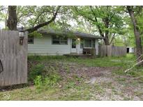 Quaint home with trees around it, situated on a large lot, complete with a classic wood fence at 338 E Park St, Westfield, IN 46074