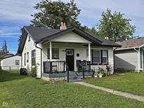 Charming one-story home with a landscaped yard, black accents, and a welcoming front porch at 3848 Spann Ave, Indianapolis, IN 46203