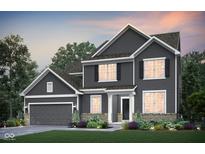 Charming two-story home boasts gray siding, a manicured lawn, and complemented by lush landscaping at 591 Dalton Way, Avon, IN 46123